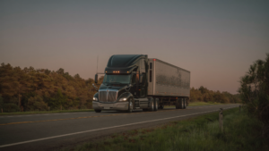 An 18-wheeler tractor-trailer traveling on a South Carolina highway at dusk
