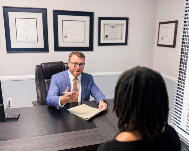 Taylor Grooms discussing a personal injury claim with a client in Charleston